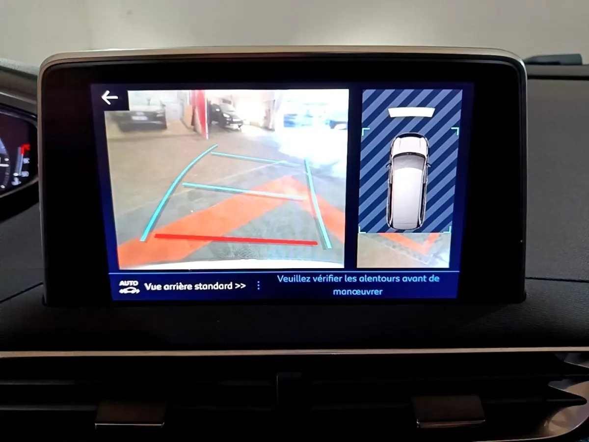 Écran tactile du système de navigation Peugeot 5008 bleu montrant la caméra de recul et l'aide au stationnement arrière.