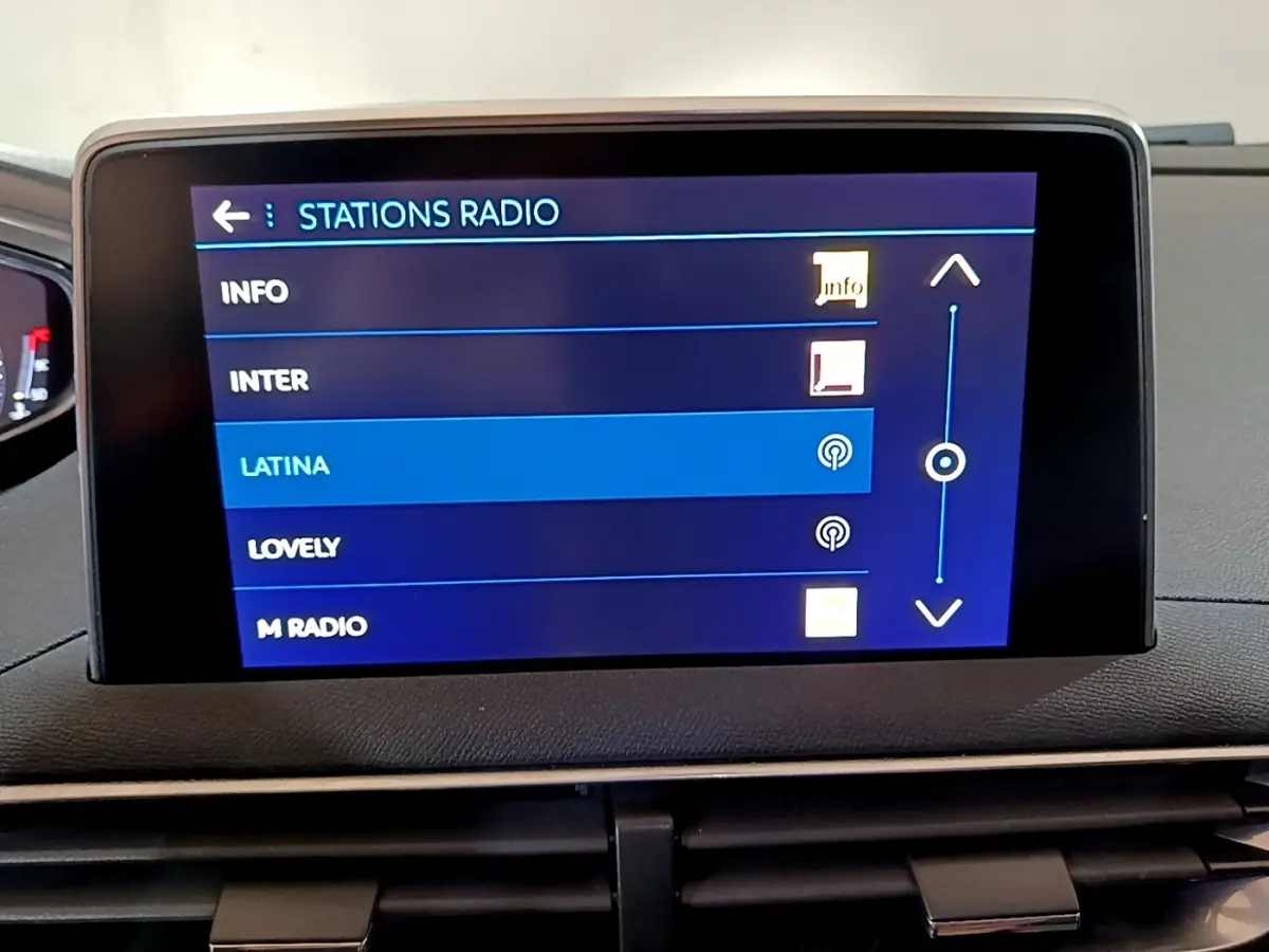 Écran tactile central du tableau de bord du Peugeot 5008 bleu, affichant la sélection des stations radio.