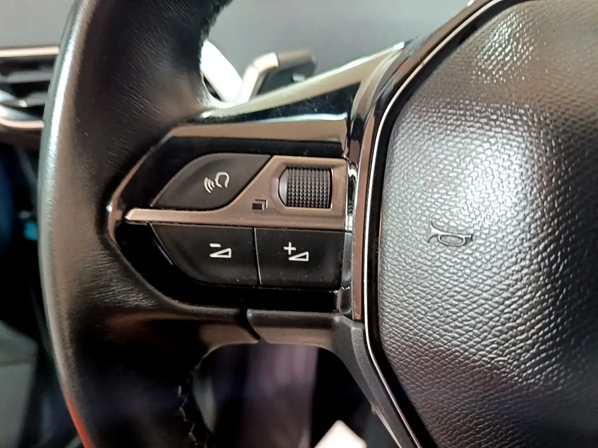 Gros plan sur les commandes gauche du volant cuir noir du Peugeot 5008 bleu, version Allure 2018.