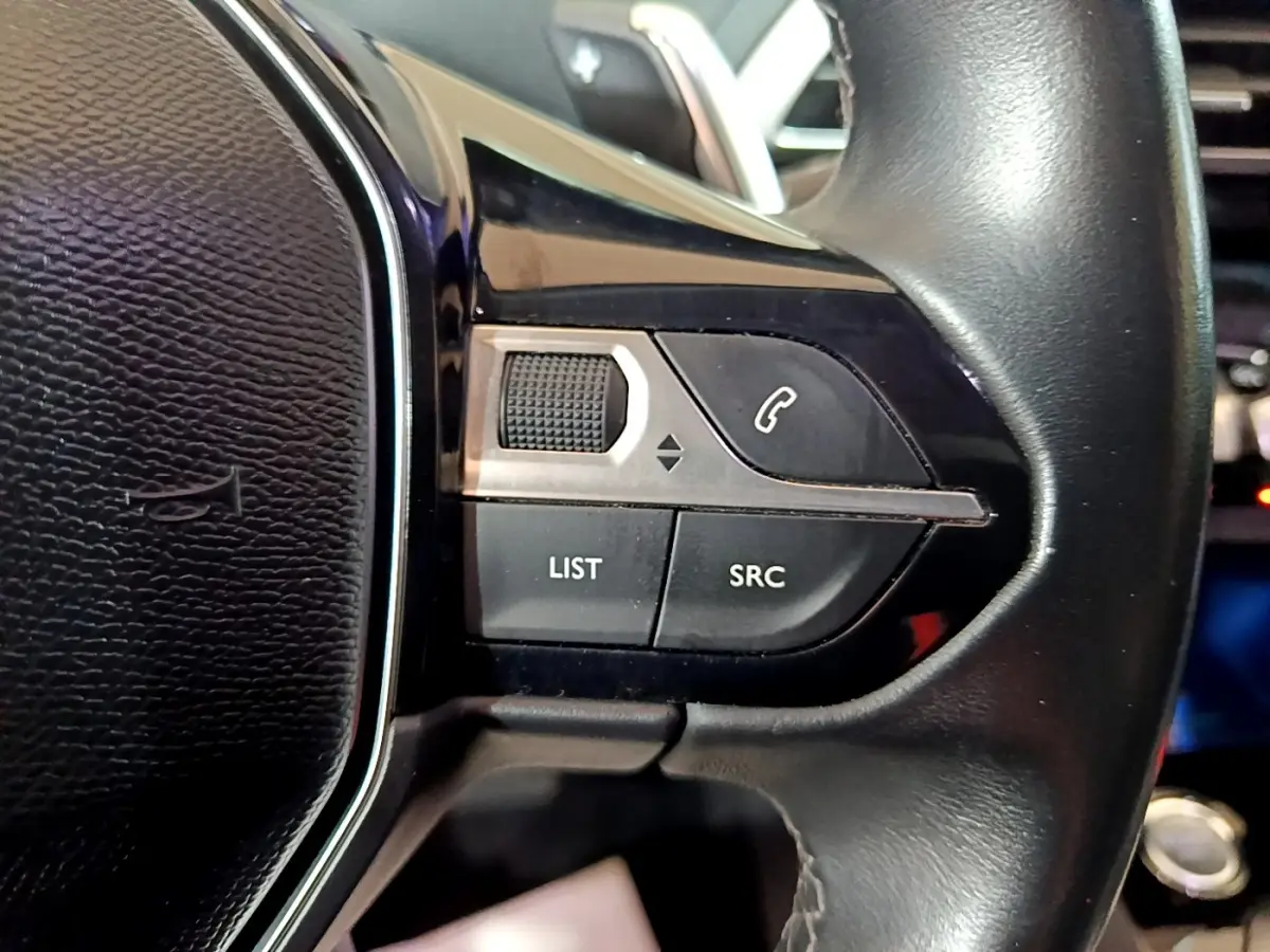 Gros plan sur les commandes du volant côté gauche du Peugeot 5008 bleu, version THP 165 S&S EAT6 Allure 2018.