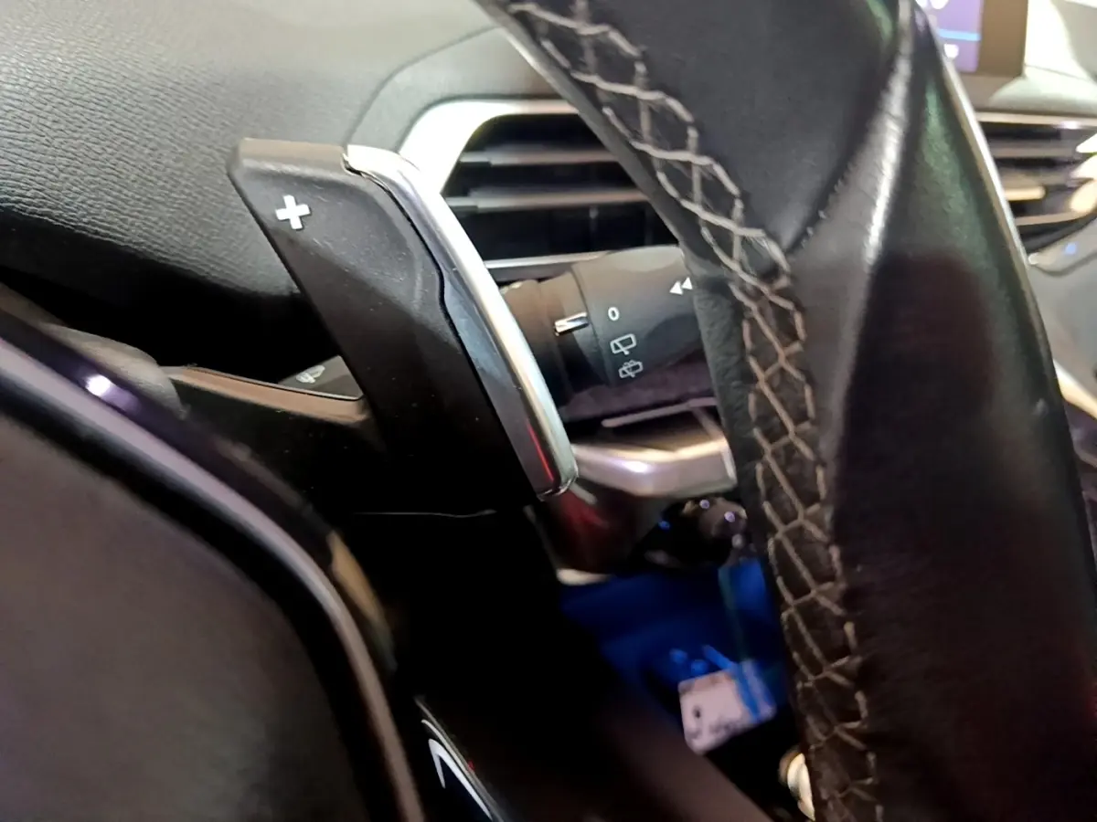 Gros plan sur la palette de changement de vitesse droite en aluminium et cuir du volant du Peugeot 5008 bleu 2018.