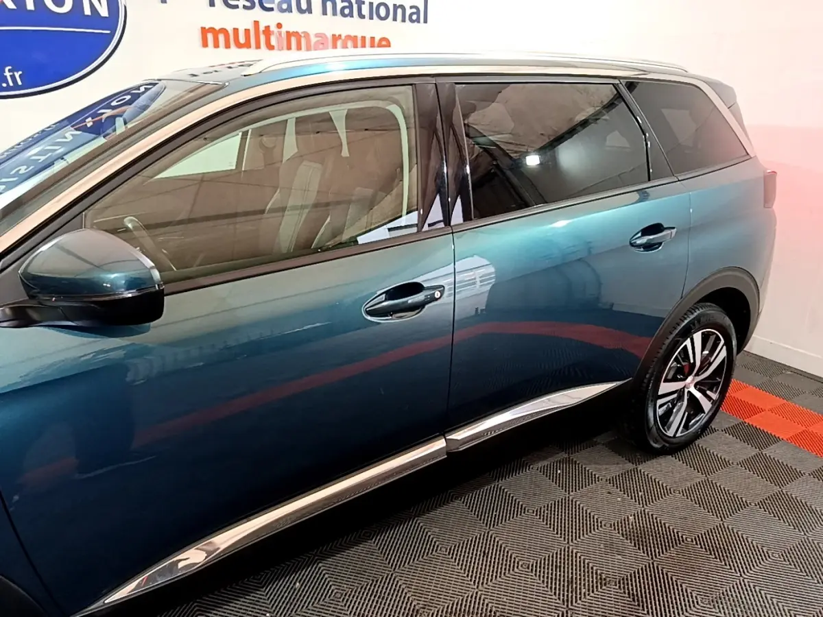 Profil côté gauche du Peugeot 5008 bleu 2018 avec vitres teintées et jantes alliage distinctives.