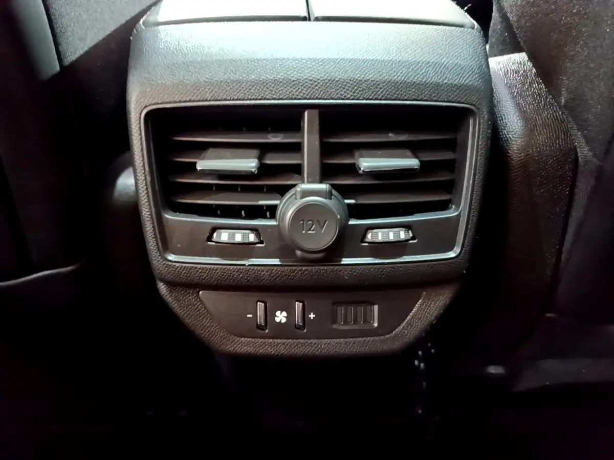 Gros plan sur la ventilation arrière noire avec prise 12V et commandes de climatisation du Peugeot 5008 bleu 2018.