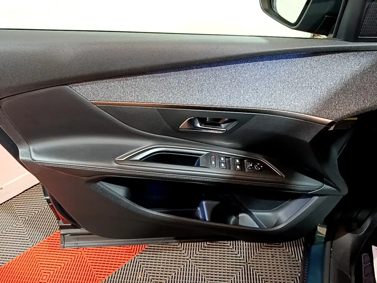 Intérieur côté gauche de porte PEUGEOT 5008 bleu 2018 avec commandes vitres et poignée argentée.