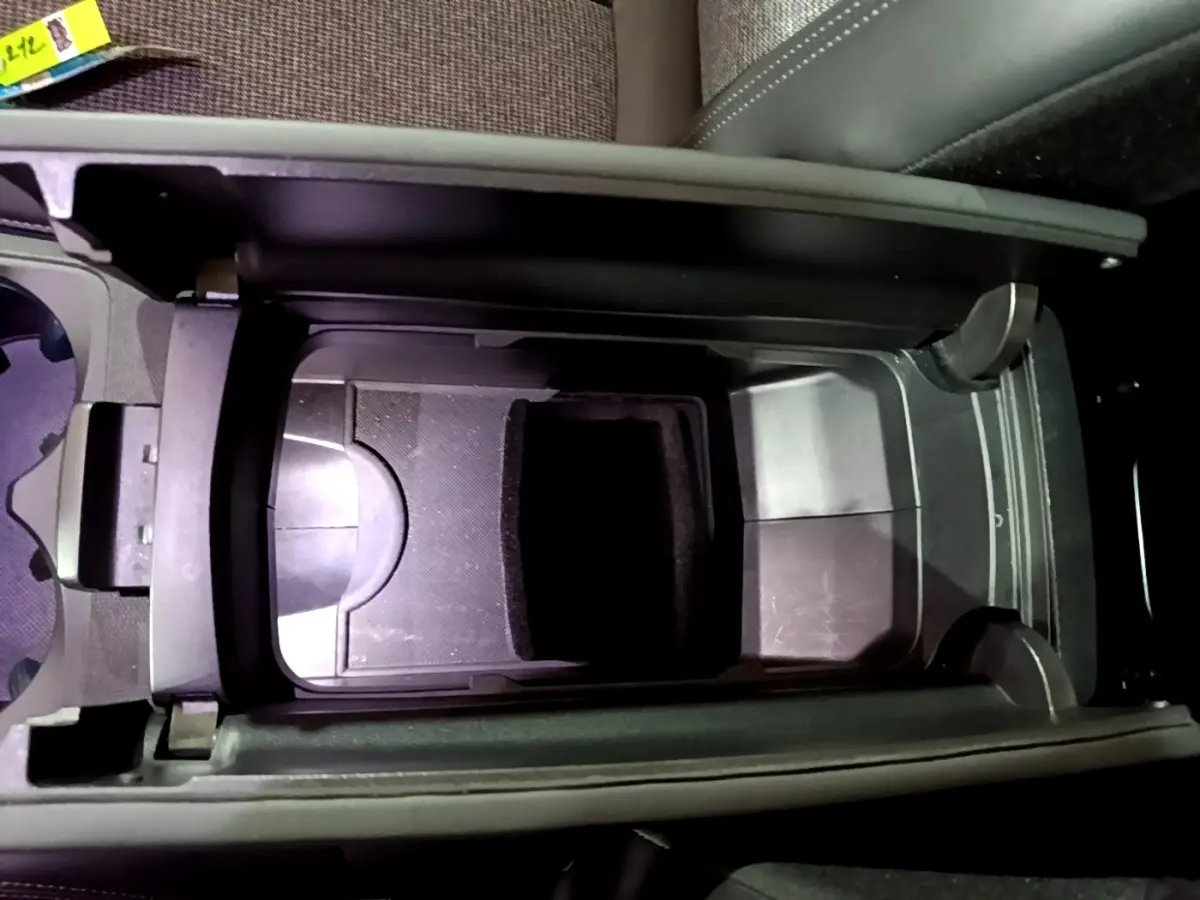 Vue plongeante sur la console centrale noire du Peugeot 5008 Allure 2018 avec rangement ouvert et porte-gobelets.