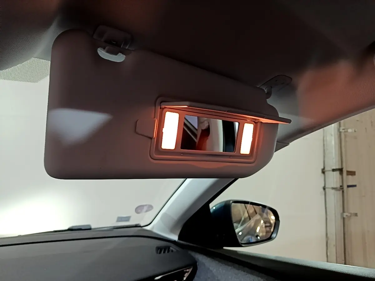 Miroir de courtoisie éclairé sur pare-soleil côté conducteur dans l’habitacle du Peugeot 5008 bleu 2018.