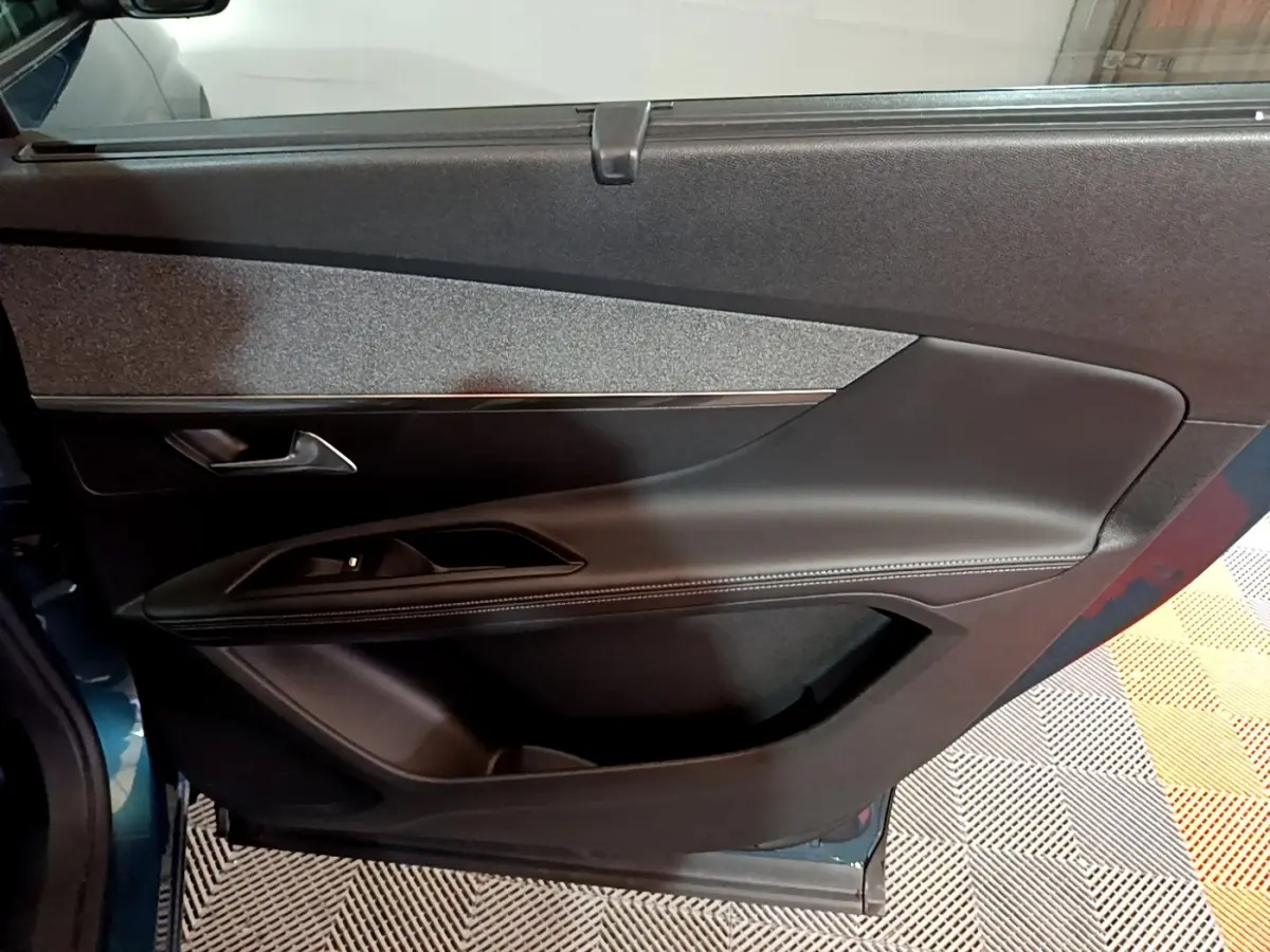 Vue rapprochée de la porte côté gauche du Peugeot 5008 bleu, avec garniture noire et poignée argentée.