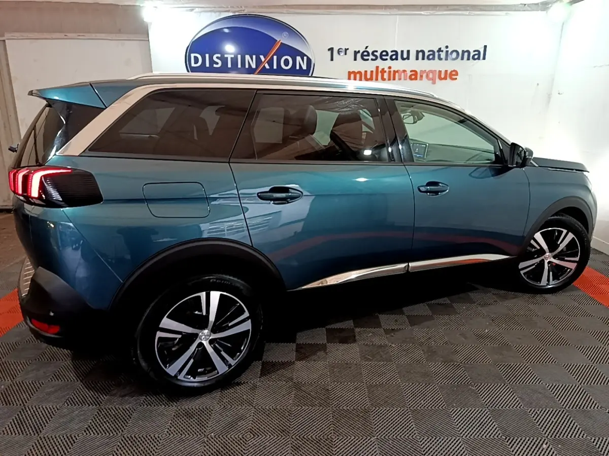Peugeot 5008 bleu vue de profil côté droit, avec jantes alliage bicolores et toit contrasté blanc.
