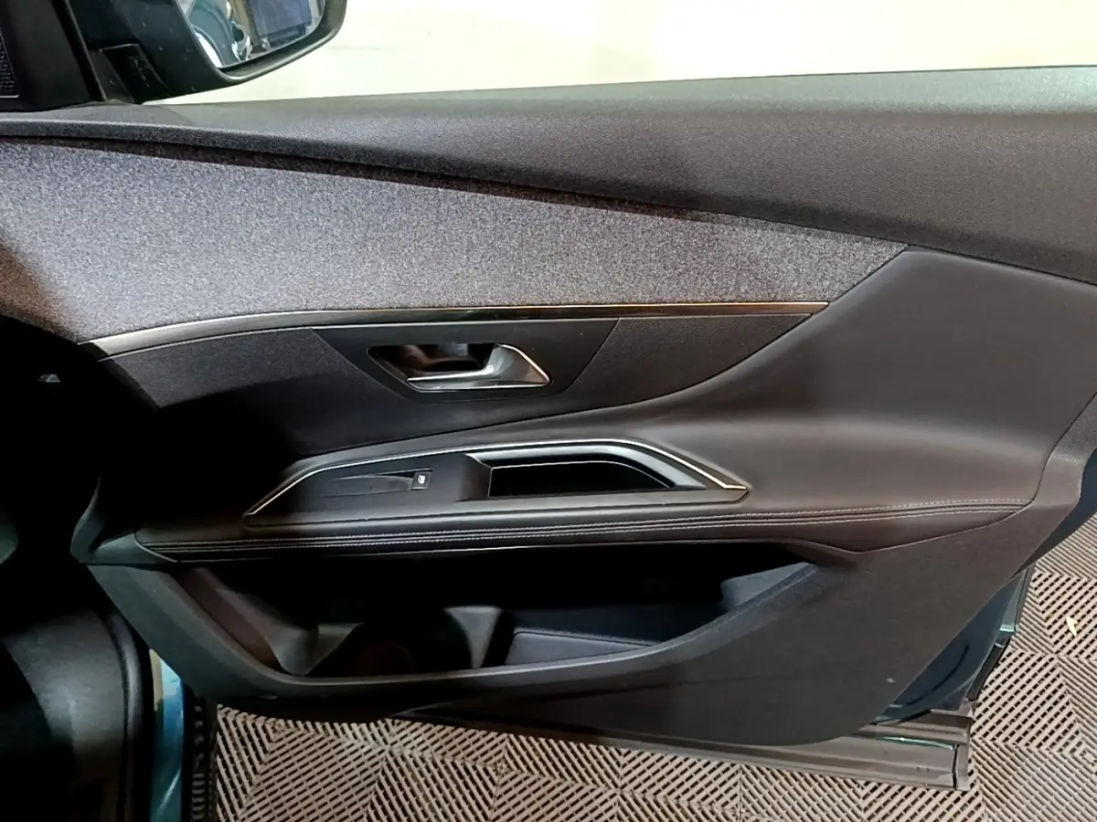 Vue rapprochée de la porte avant gauche du Peugeot 5008 bleu, avec garniture noire et insert décoratif chromé.