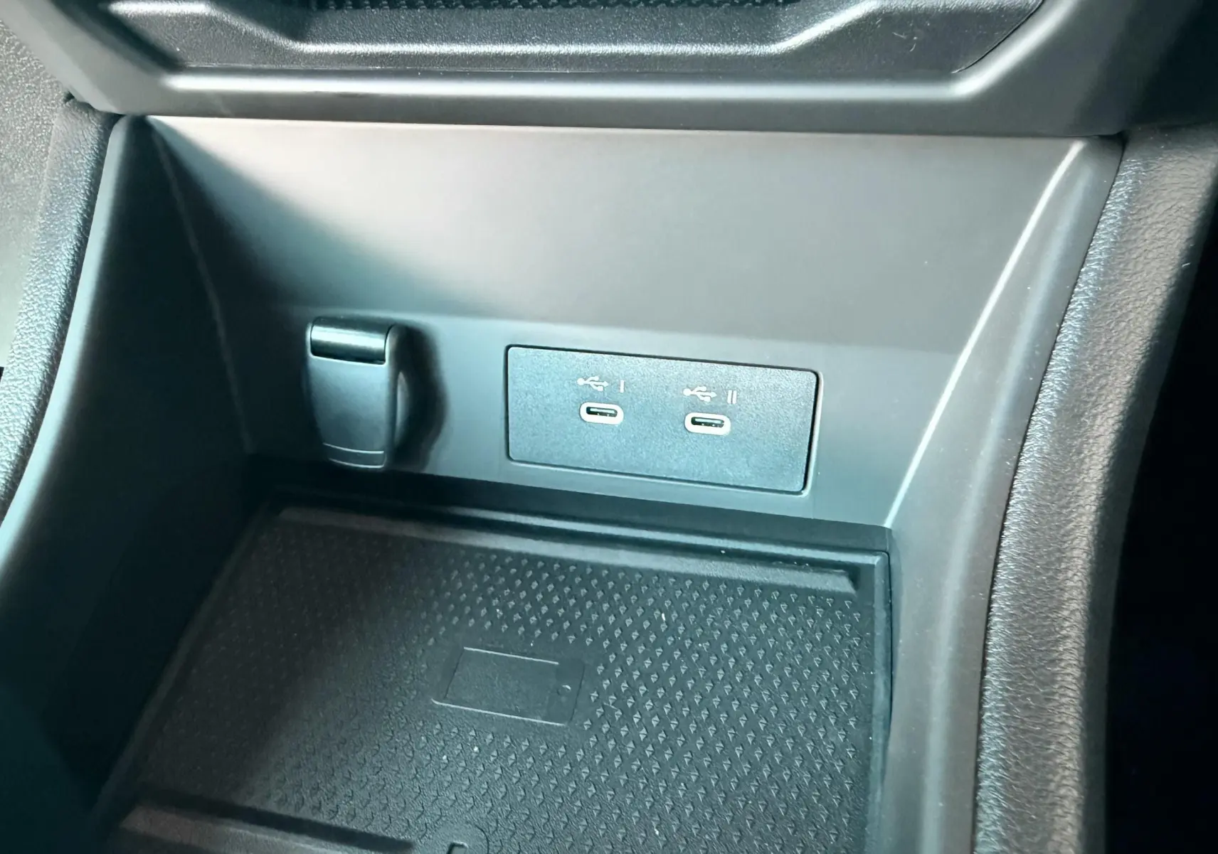 Gros plan sur la console centrale noire du Renault Captur 2025 avec deux ports USB-C et un espace de rangement.