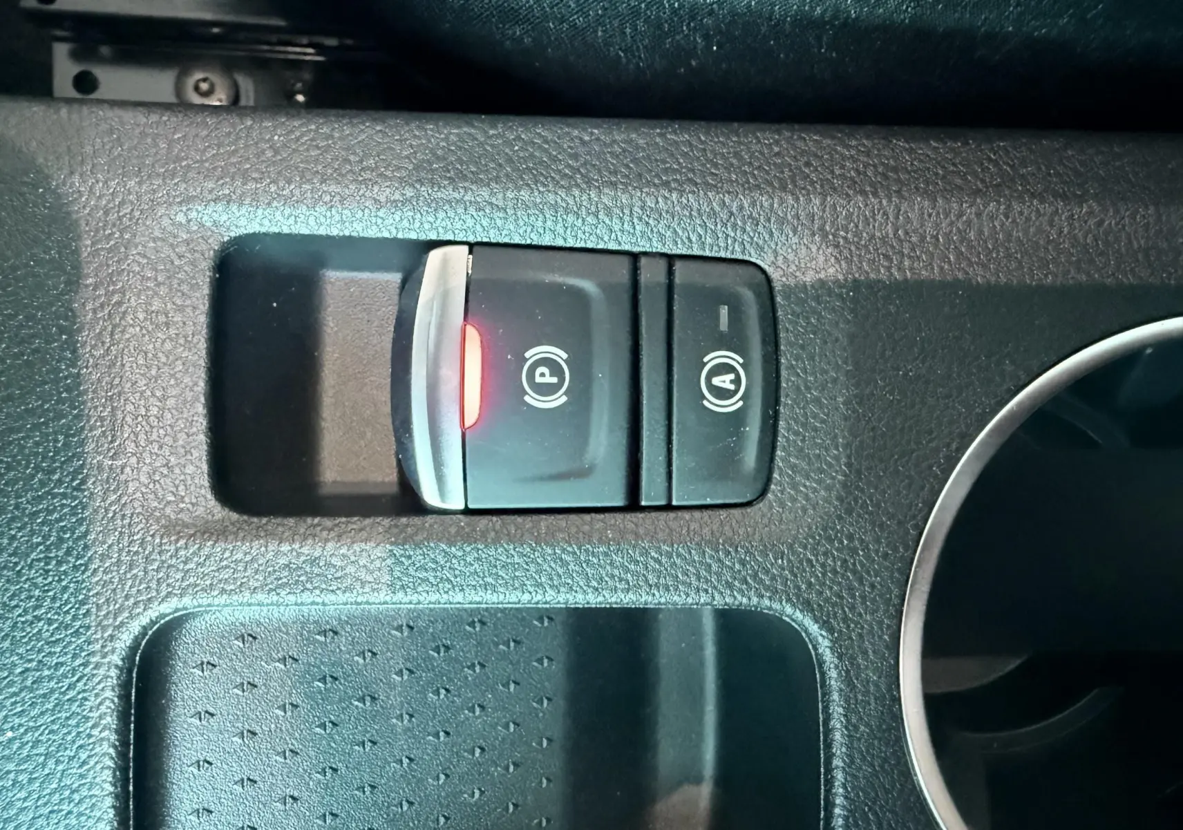 Gros plan sur les commandes de frein à main électronique et arrêt/démarrage automatique dans un Renault Captur noir.
