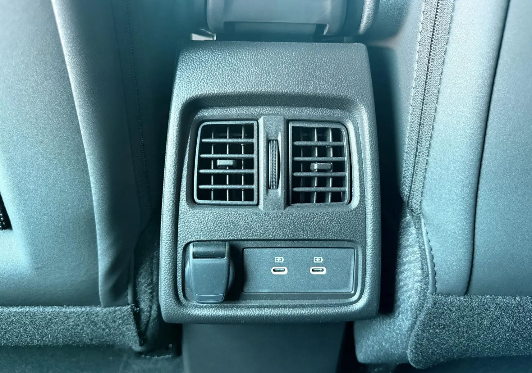 Vue rapprochée des aérateurs arrière et des ports USB-C du Renault Captur 2025, intérieur tissu gris-noir.