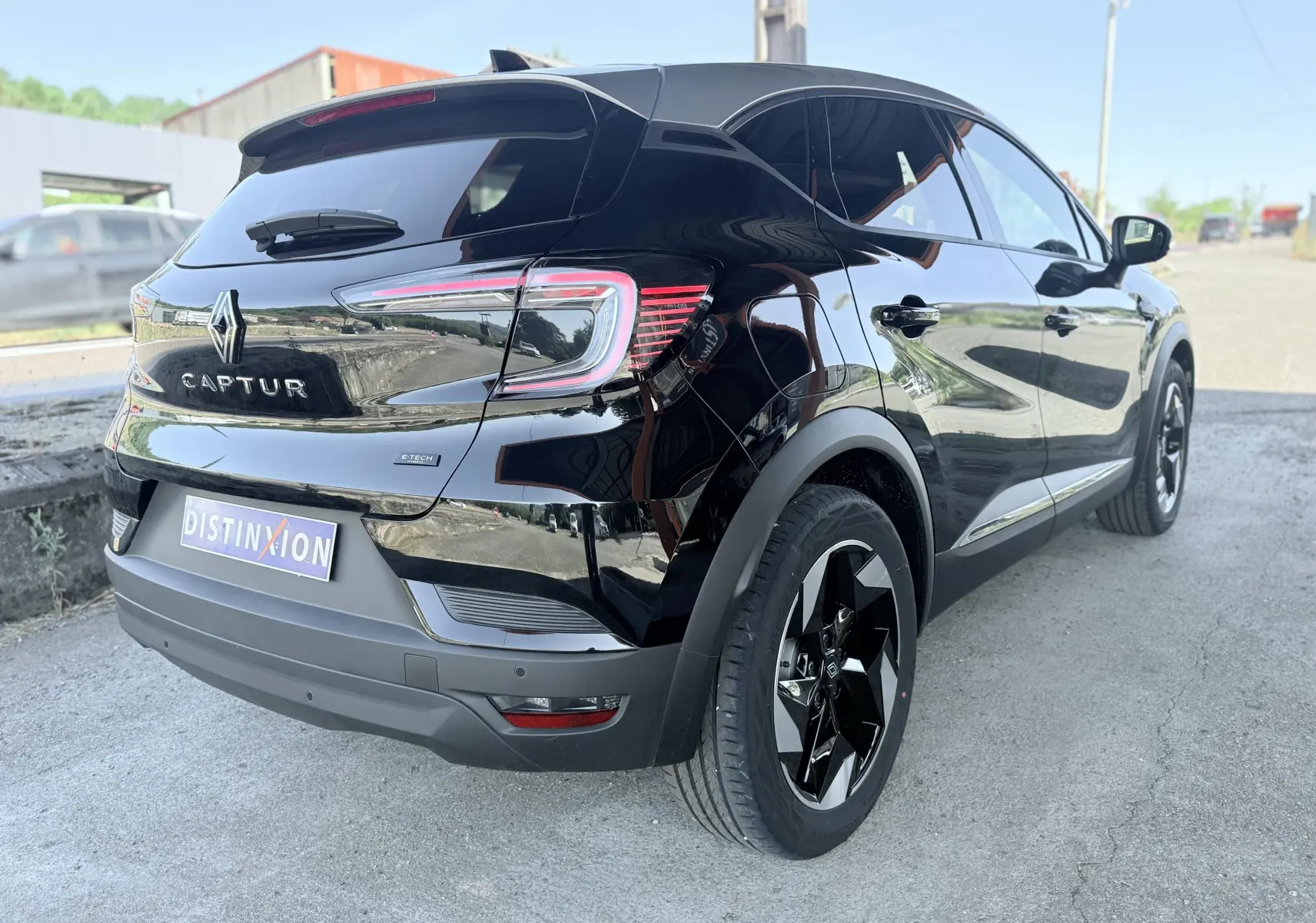 Vue 3/4 arrière droite d’un Renault Captur noir brillant avec jantes noires et feux arrière LED distinctifs.