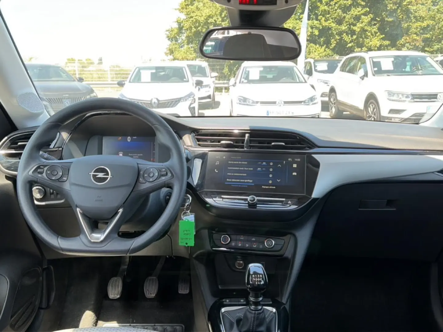 Vue intérieure avant de l’Opel Corsa noire 2025, mettant en valeur le volant multifonction et l’écran tactile central.