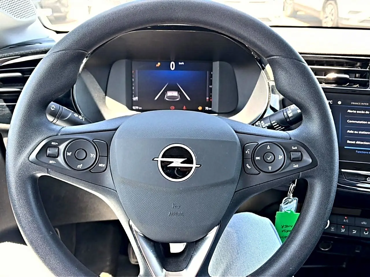 Vue intérieure centrée sur le volant noir multifonction de l’Opel Corsa 1.2 turbo 100 edition avec tableau de bord numérique.