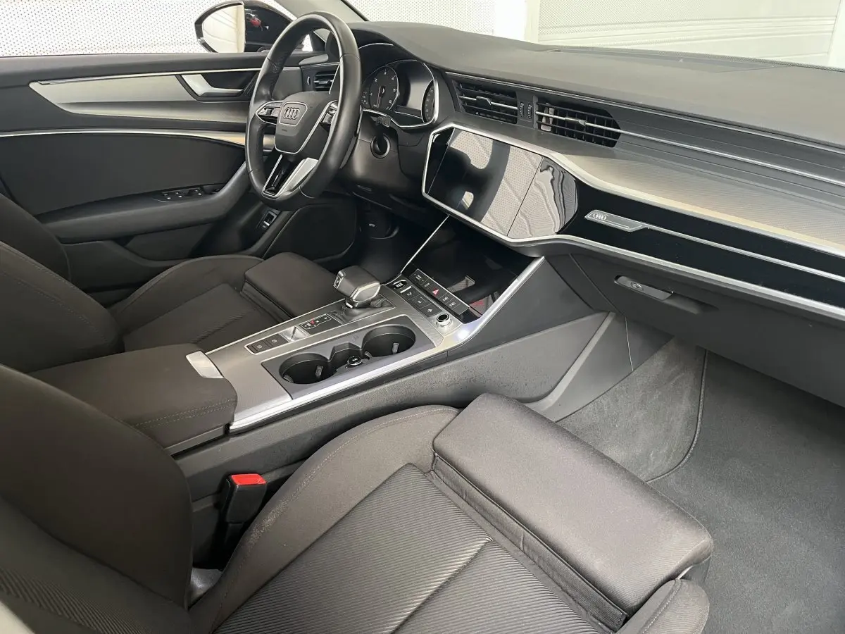 Intérieur noir de l'Audi A6 40 TDI Prestige 2022 vu côté passager, avec tableau de bord moderne et console centrale épurée.