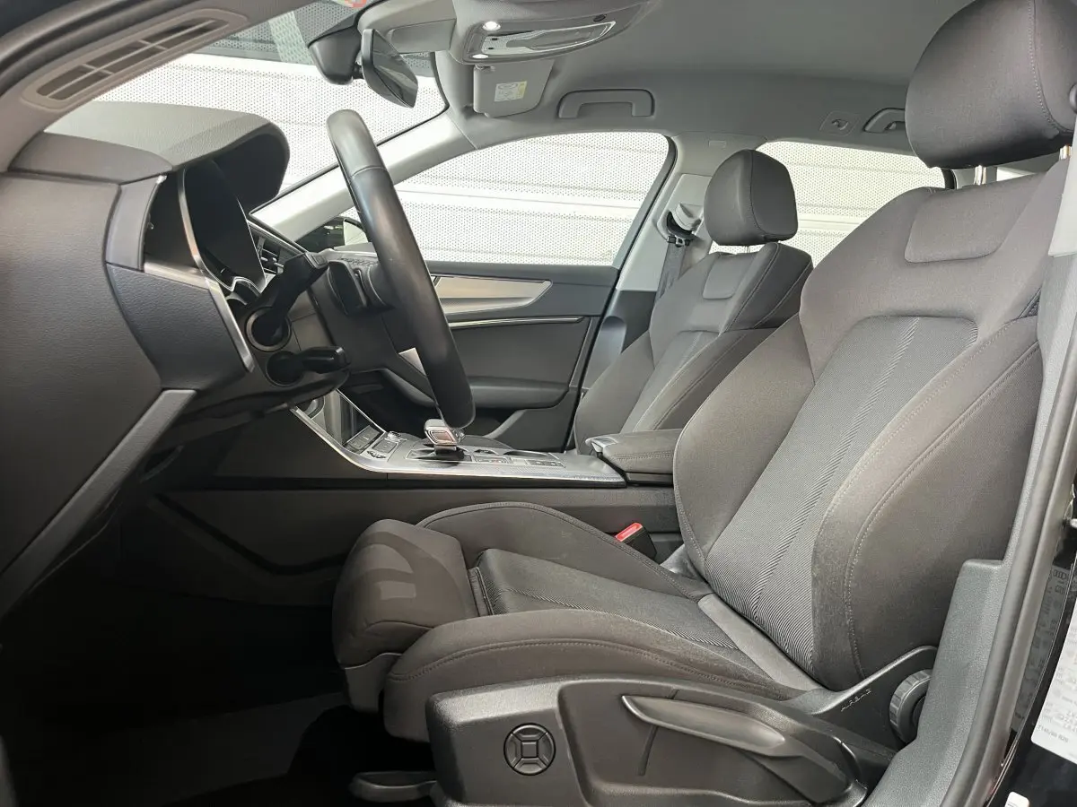 Vue intérieure côté conducteur de l'Audi A6 40 TDI Prestige 2022 avec sièges tissu gris et tableau de bord moderne.