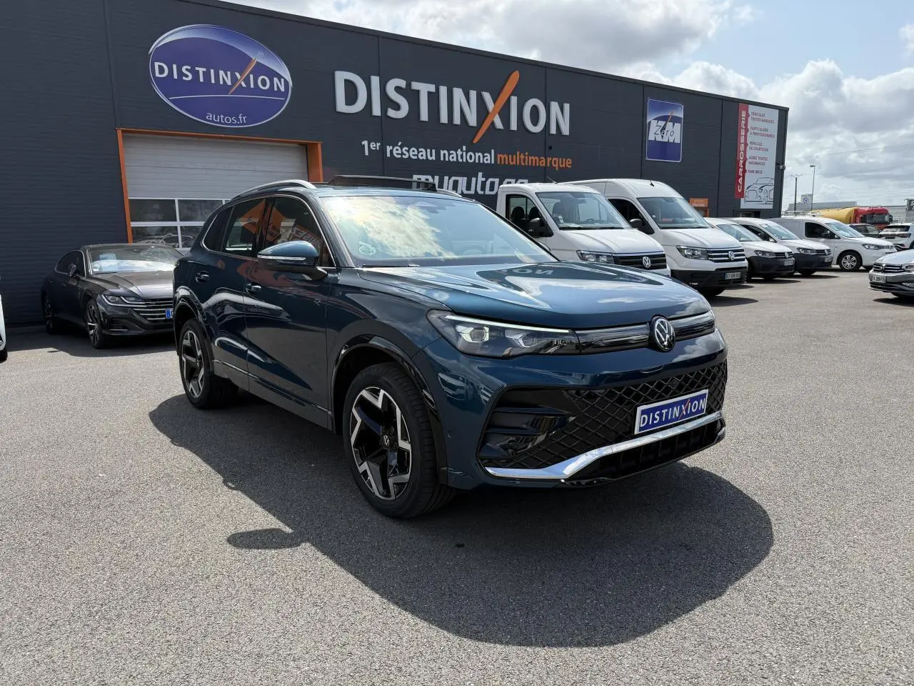 Volkswagen Tiguan 2024 bleu métallisé en 3/4 avant droit avec jantes R-Line et calandre noire distinctive.