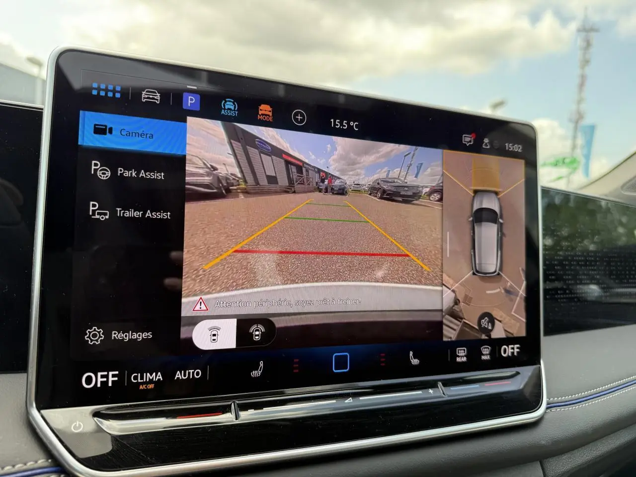 Écran tactile intérieur du Volkswagen Tiguan 2024 montrant l'assistance au stationnement avec vue caméra arrière et 360°
