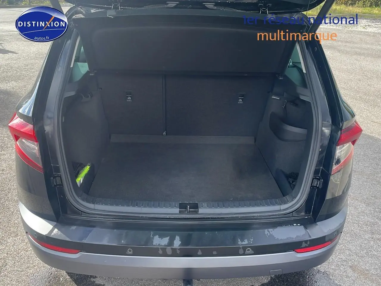 Coffre ouvert vu de l'arrière d'un Skoda Karoq noir 2018 avec hayon électrique et feux arrière LED.