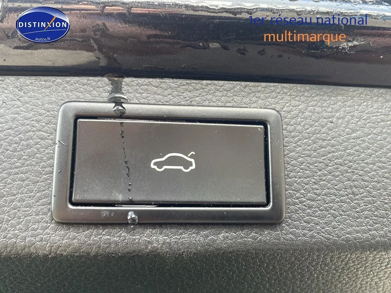 Bouton d'ouverture du hayon noir sur tableau de bord texturé d'un Skoda Karoq 2018 diesel.