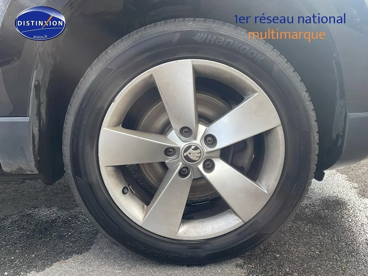 Gros plan sur la roue avant gauche du Skoda Karoq noir 2018 avec jante alliage cinq branches.