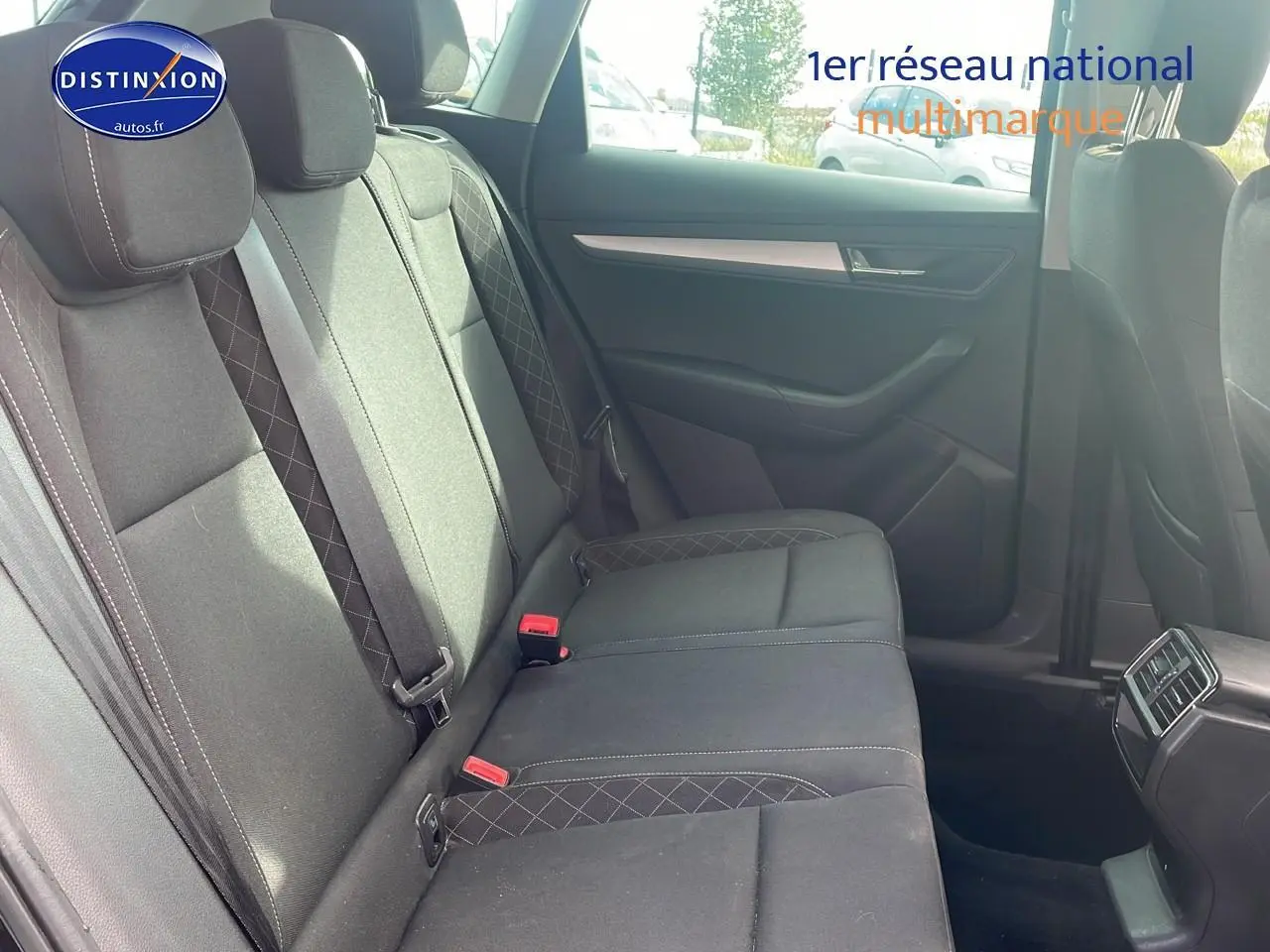 Vue latérale des sièges arrière noirs en tissu du Skoda Karoq 1.6 TDI Business 2018 avec ceintures et aérateurs centraux.