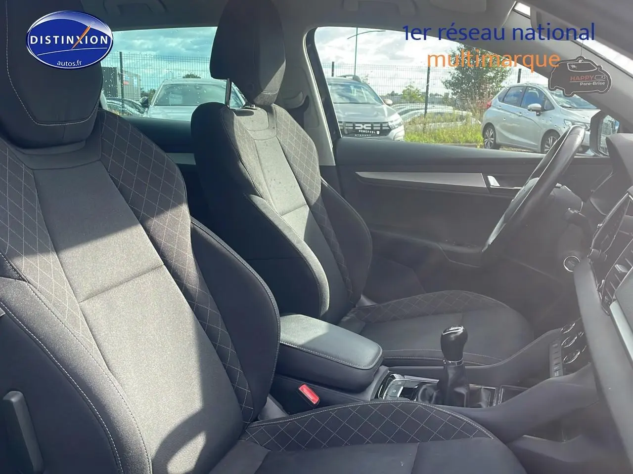 Intérieur avant du Skoda Karoq 1.6 TDI noir, vue côté droit avec sièges tissu et levier de vitesse manuel visible.