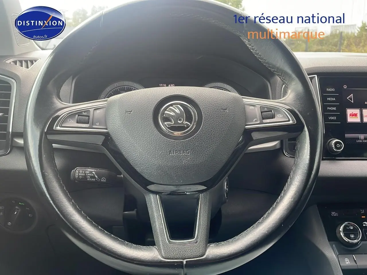 Vue rapprochée du volant cuir multifonction d'une Skoda Karoq 2018 avec tableau de bord et écran tactile visibles.