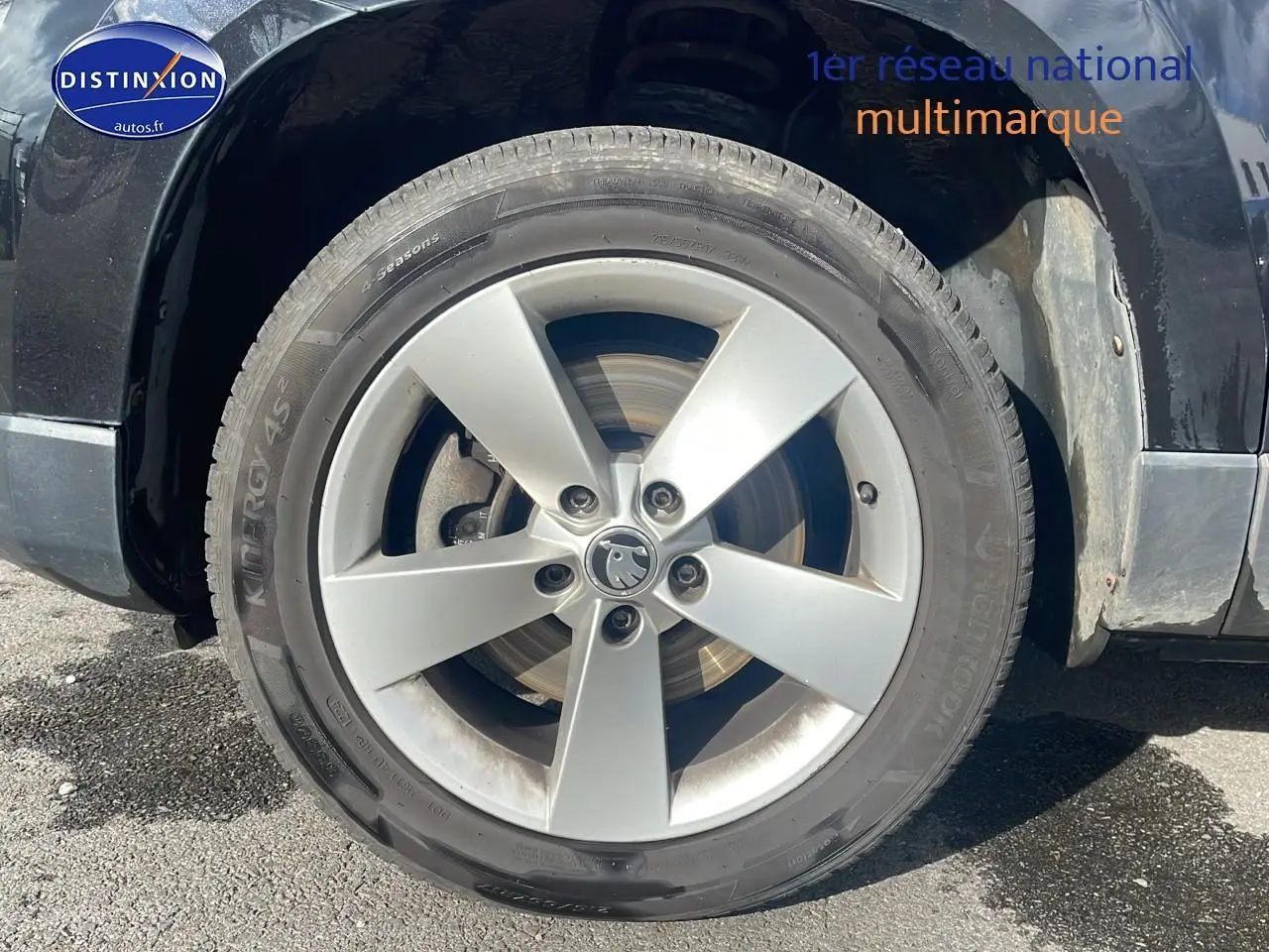 Gros plan sur la roue avant gauche en jante alu argentée d'un Skoda Karoq noir 2018.