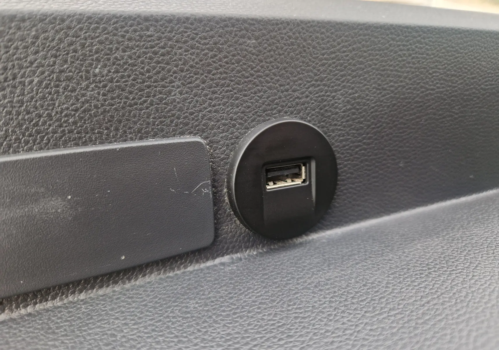 Gros plan sur un port USB intégré dans le tableau de bord noir texturé du Renault Master Châssis Cabine blanc 2024.