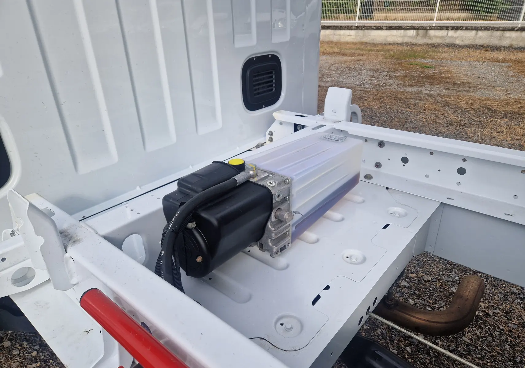 Vue rapprochée de la benne blanche arrière du Renault Master Châssis Cabine 2024 avec réservoir et structure métallique visible.
