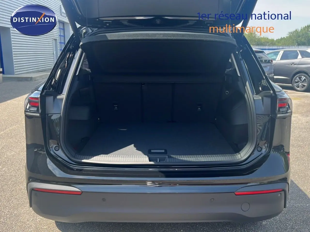Vue arrière du Volkswagen Tiguan noir Grenadilla métallisé 2026 avec coffre ouvert et intérieur spacieux visible.