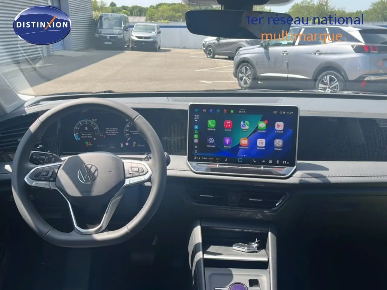 Vue intérieure du tableau de bord du Volkswagen Tiguan 2026, avec volant noir et écran tactile central lumineux.