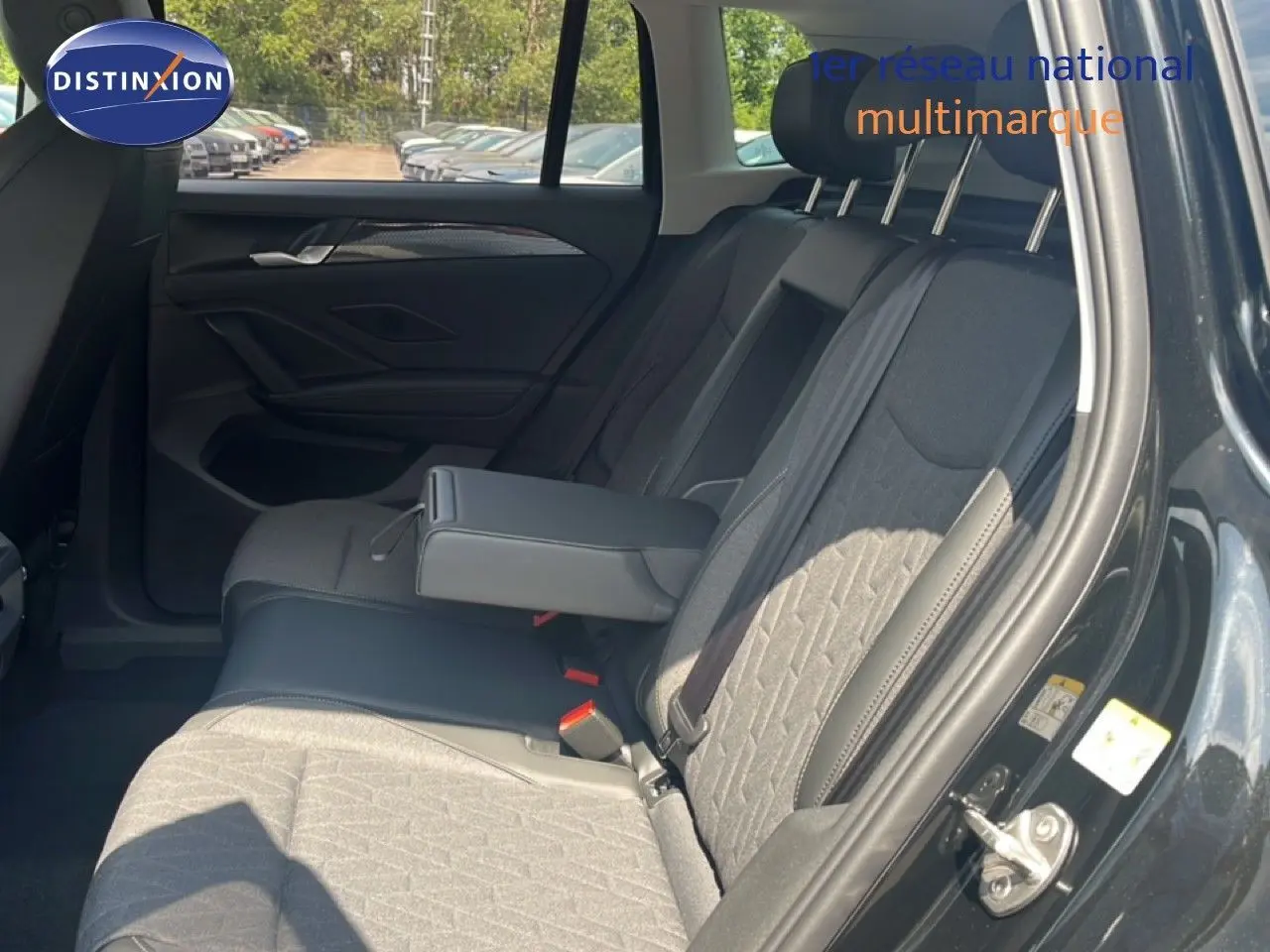 Vue intérieure côté droit des sièges arrière du Volkswagen Tiguan noir Grenadilla, avec accoudoir central déployé.