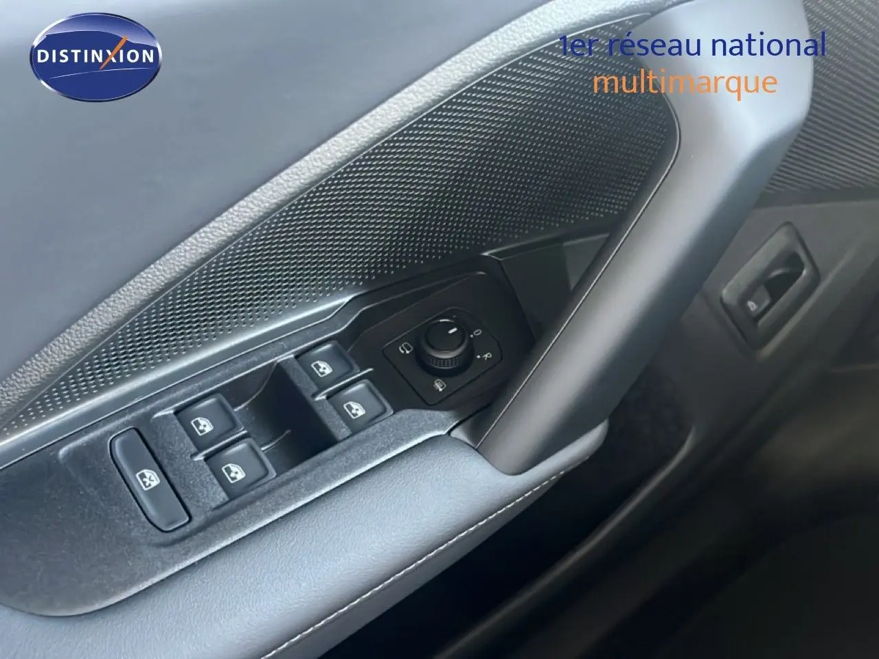 Gros plan sur la commande des vitres et rétroviseurs côté gauche de la porte intérieure du Volkswagen Tiguan noir Grenadilla 2026.
