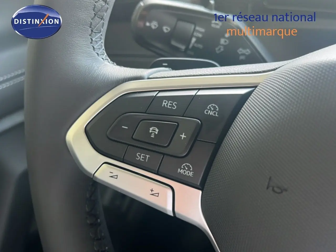 Gros plan sur les commandes au volant du Volkswagen Tiguan 2026, finition noire avec boutons de régulateur de vitesse.