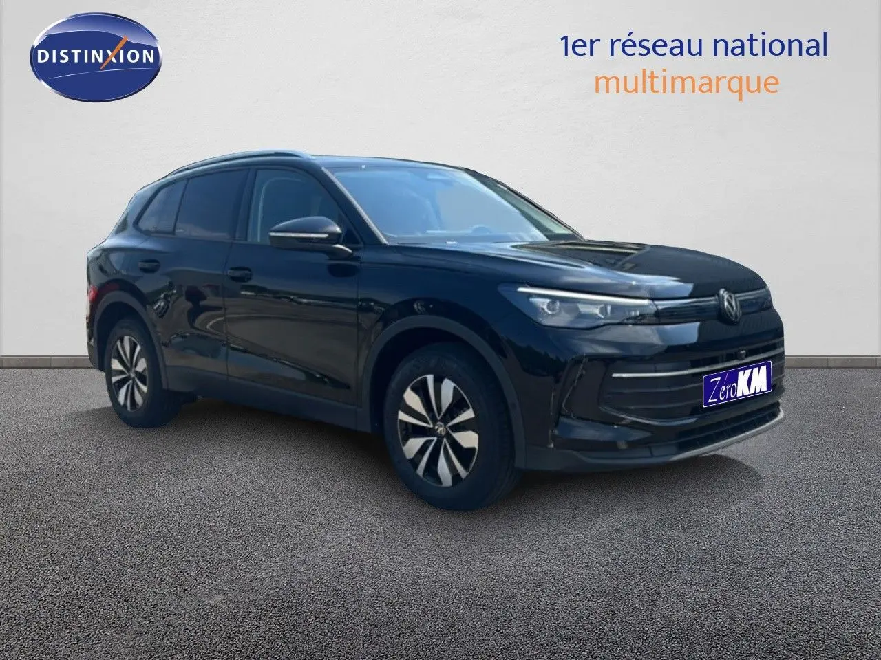 Volkswagen Tiguan 1.5 TSI noir grenadilla métal en 3/4 avant droit avec jantes bi-ton et calandre moderne.