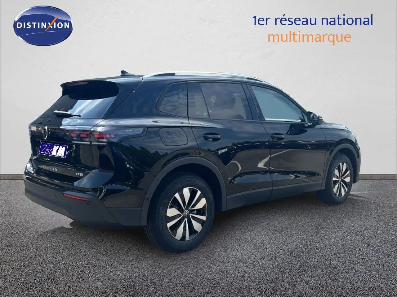 Volkswagen Tiguan noir grenadilla métal vu en 3/4 arrière droit, avec jantes bicolores et toit argenté.