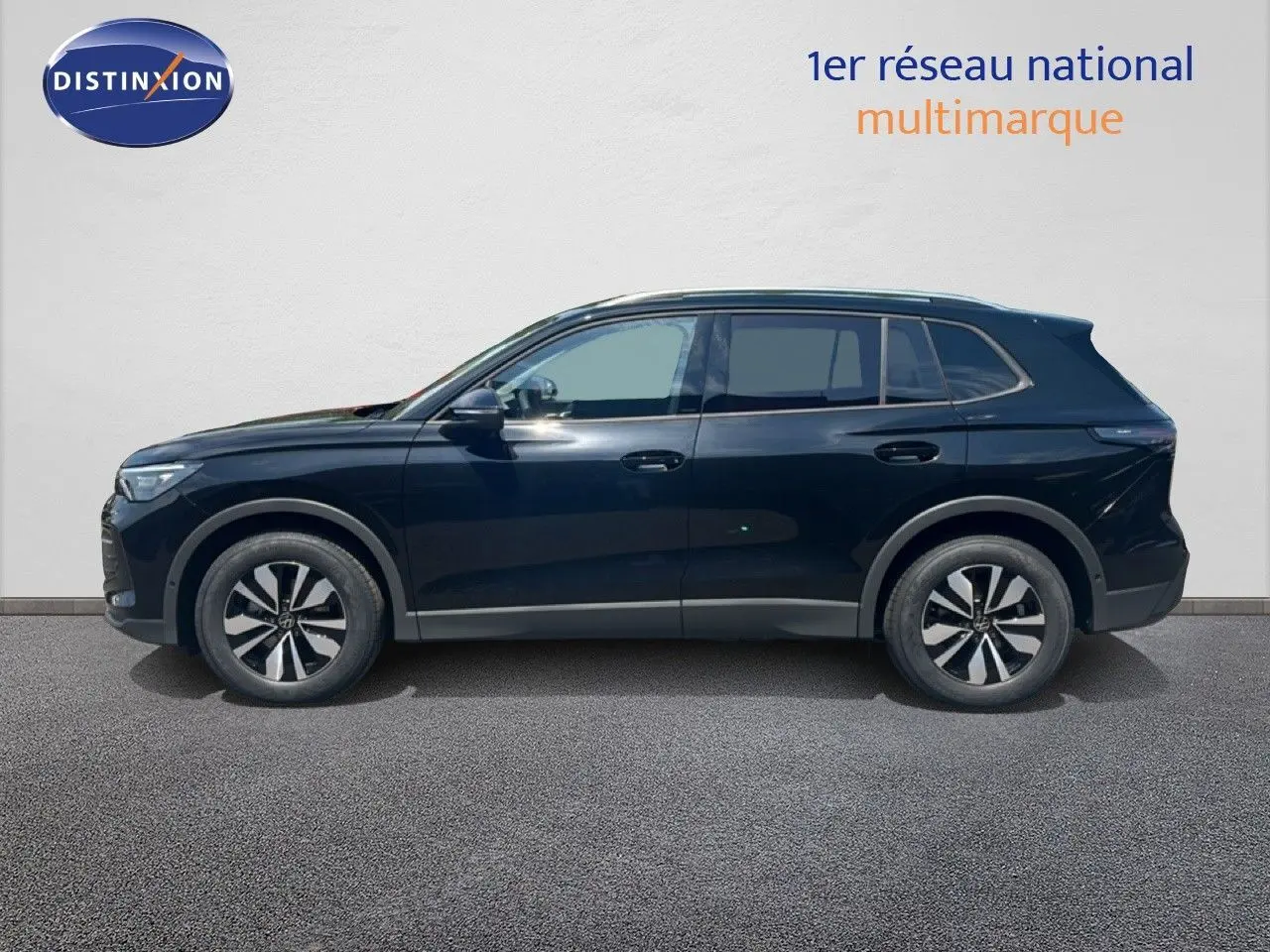 Profil droit du Volkswagen Tiguan noir Grenadilla métallisé, finition 30 Years, sur fond clair neutre.