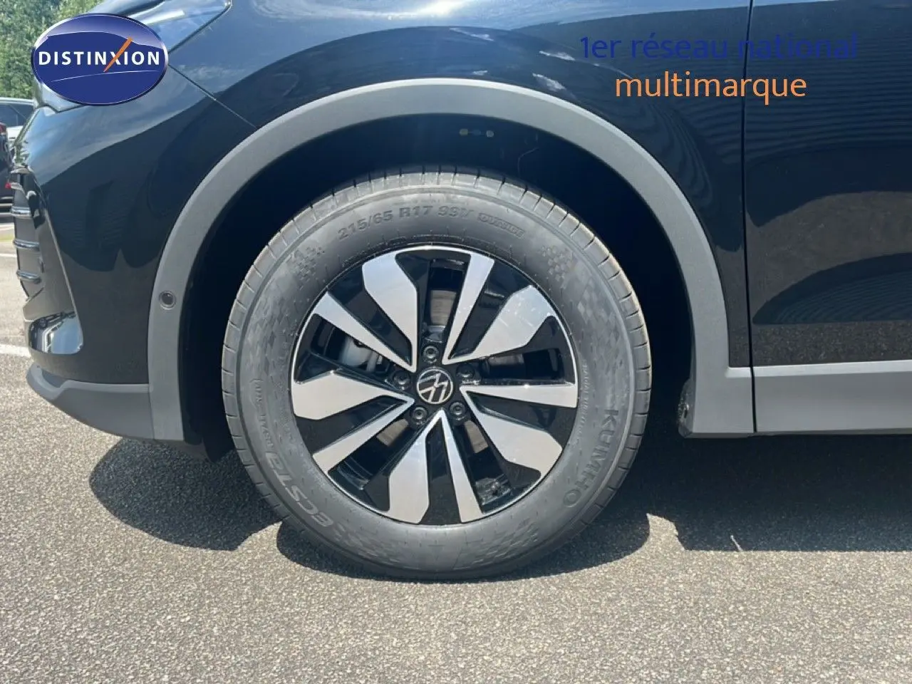 Gros plan sur la roue avant gauche du Volkswagen Tiguan noir Grenadilla 2026 avec jante alliage bicolore distinctive.