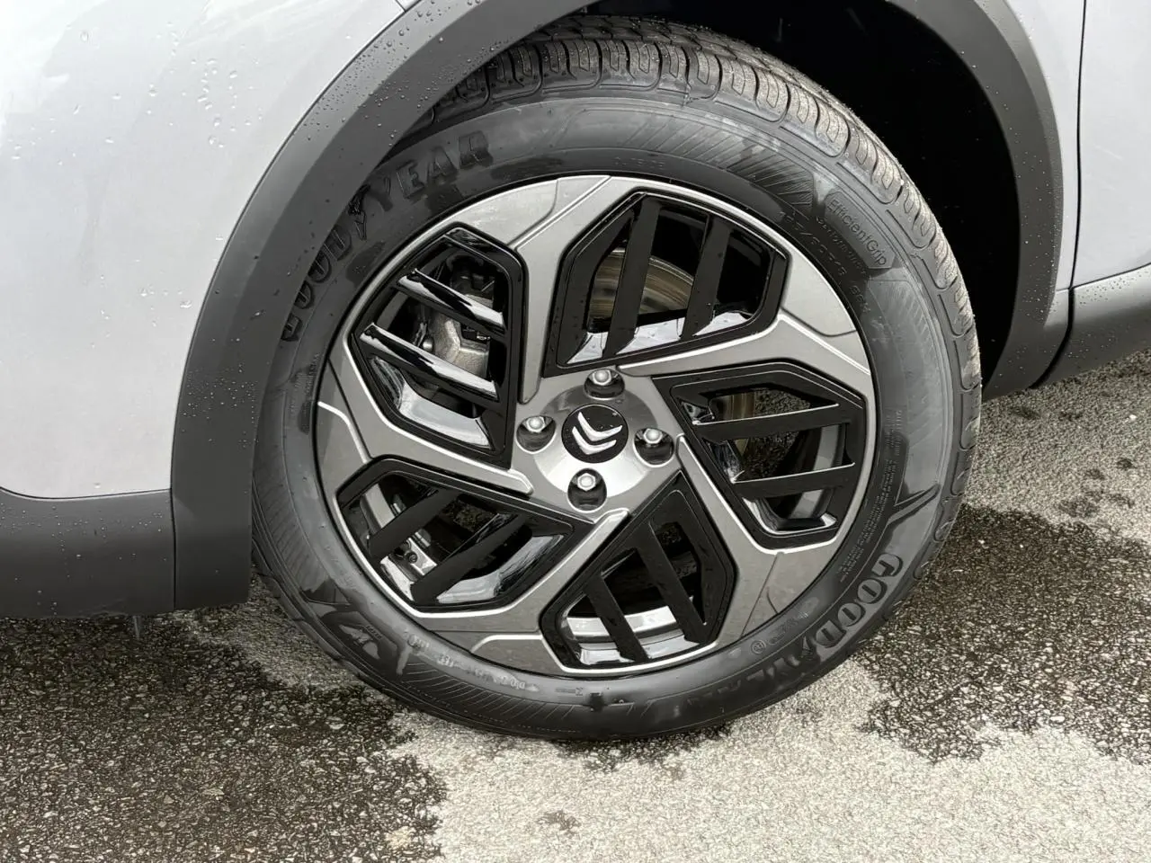 Gros plan sur la roue avant droite de la Citroën C4 gris acier, avec jante alliage diamantée noire et pneu Goodyear.