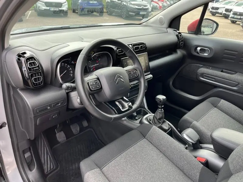Intérieur de la Citroën C3 Aircross 2020 en gris, vue côté conducteur montrant volant cuir, tableau de bord et levier manuel.