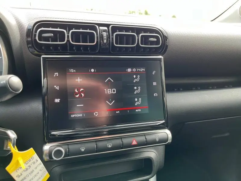 Gros plan sur l'écran tactile et les aérateurs noirs du tableau de bord d'une Citroën C3 Aircross gris acier.