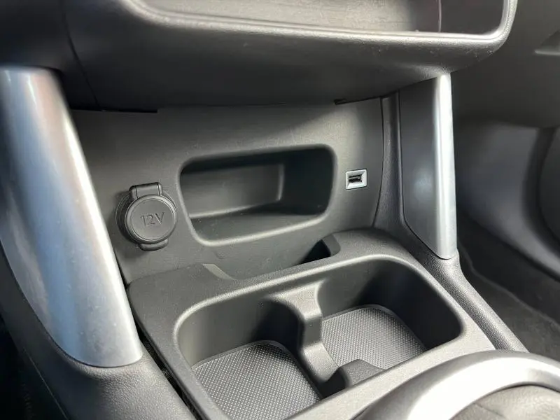 Gros plan sur la console centrale intérieure du Citroën C3 Aircross gris acier, montrant prise 12V et port USB.