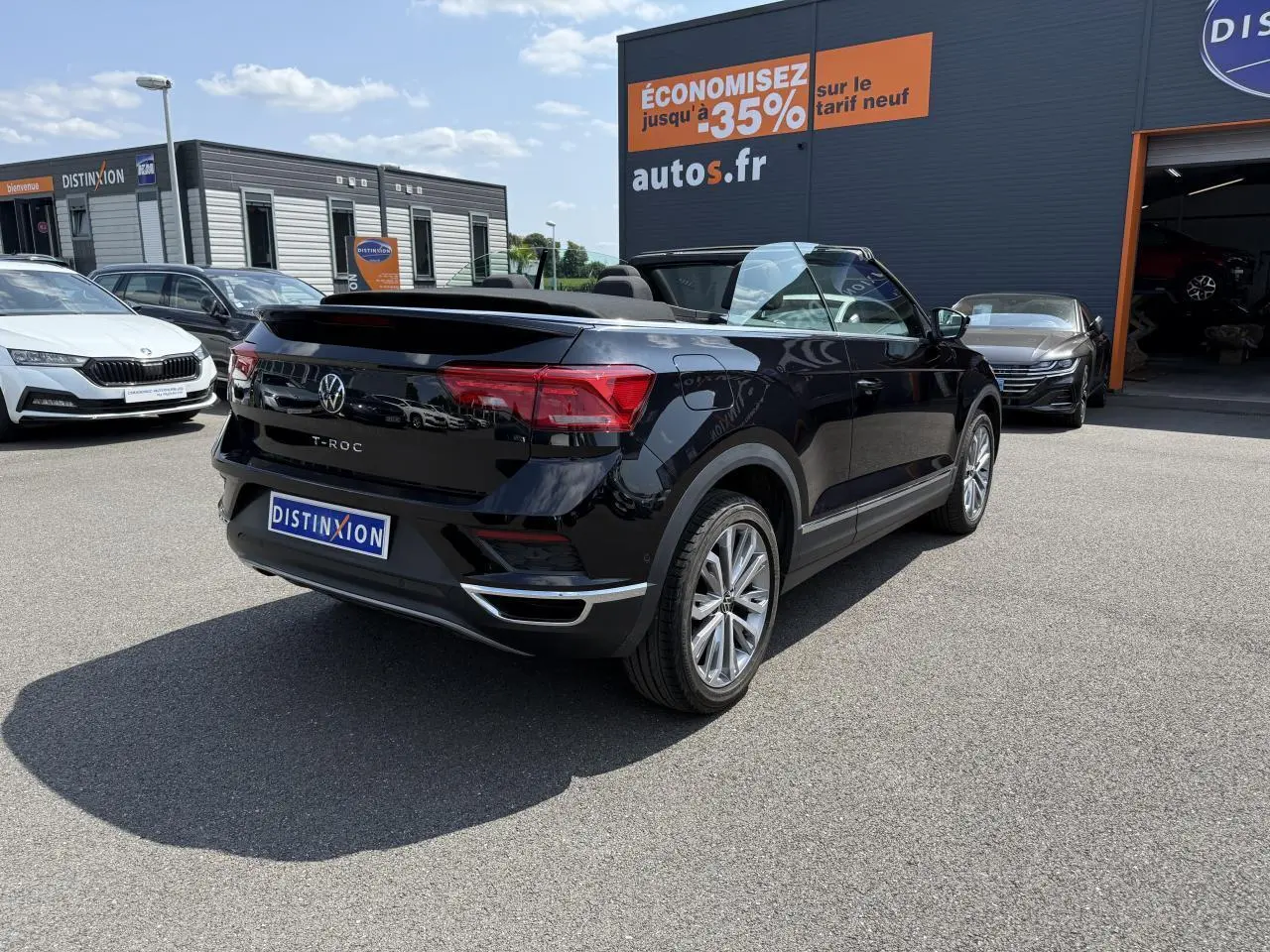 Volkswagen T-Roc Cabriolet Deep Black nacré vu de l'arrière droit, capote ouverte, jantes alliage 18 pouces visibles.