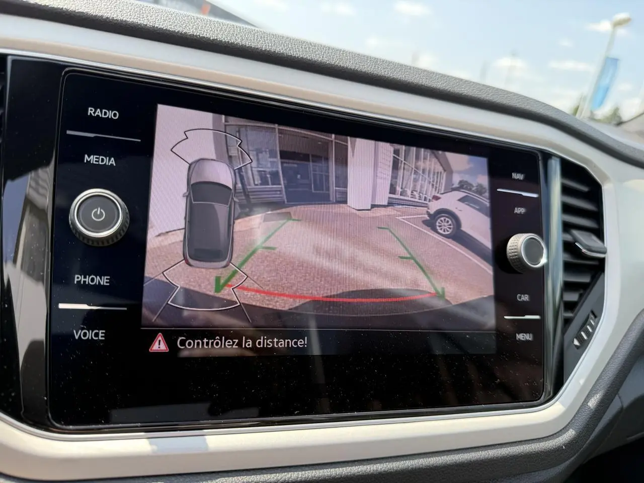 Écran tactile du tableau de bord montrant la caméra de recul du Volkswagen T-Roc Cabriolet noir Deep Black nacré.