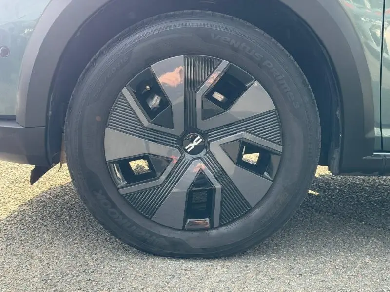 Gros plan sur la roue avant gauche du Dacia Jogger 2025 en Vert Cèdre métallisé avec jante au design moderne noir et gris.