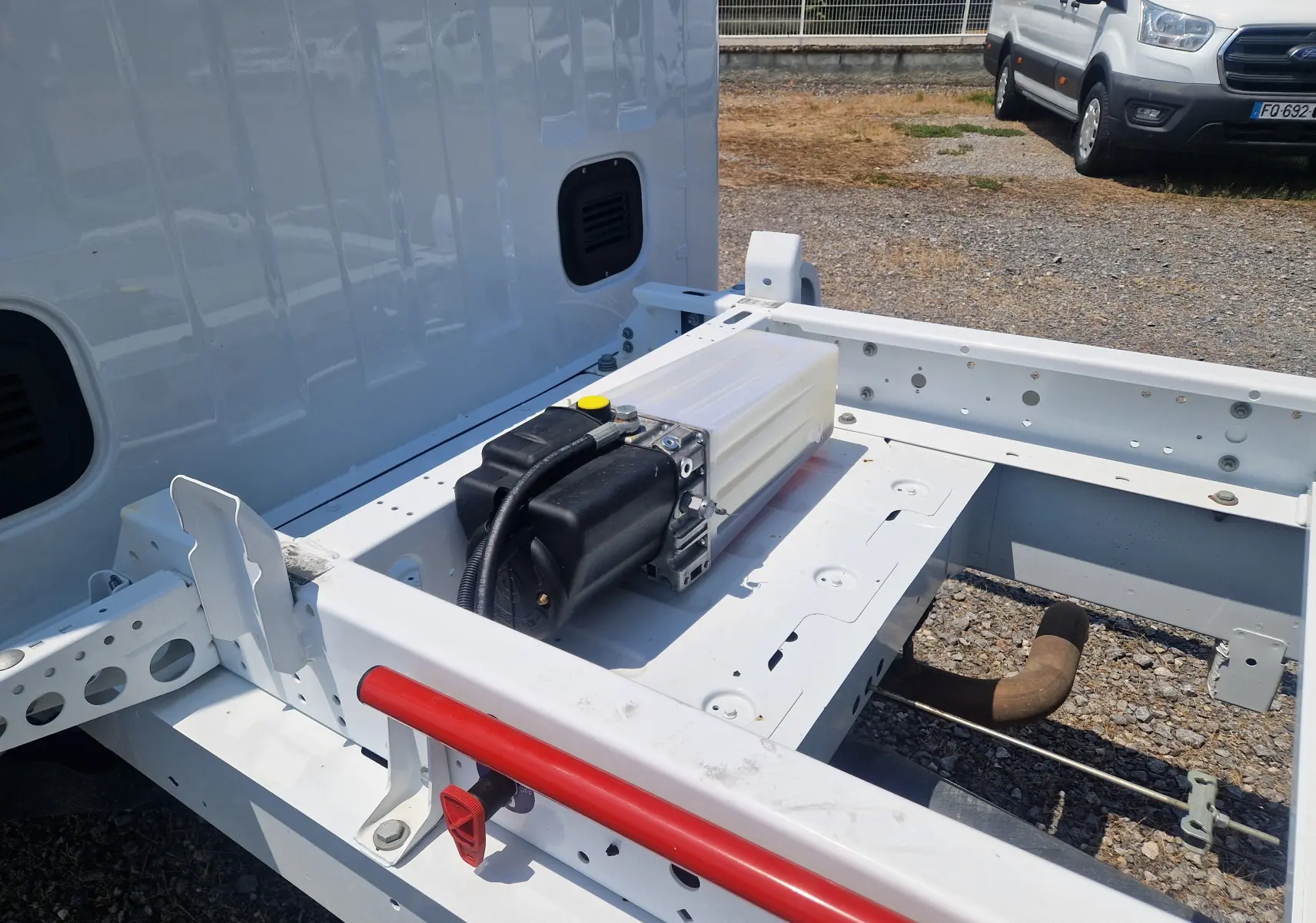 Détail de la benne arrière blanche du Renault Master Châssis Cabine 2024, vue latérale droite avec réservoir et cadre métallique apparent.