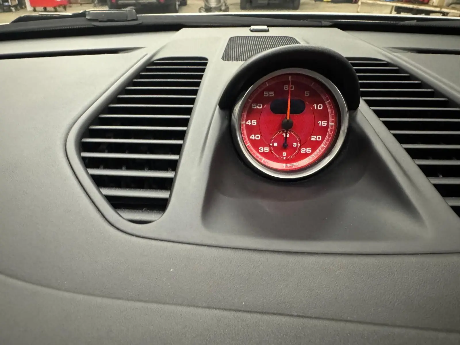 Gros plan sur le chronomètre rouge du tableau de bord gris d'une Porsche 911 991 2 Carrera T.